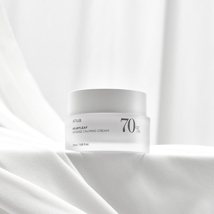 White jar of skincare cream on a white fabric background